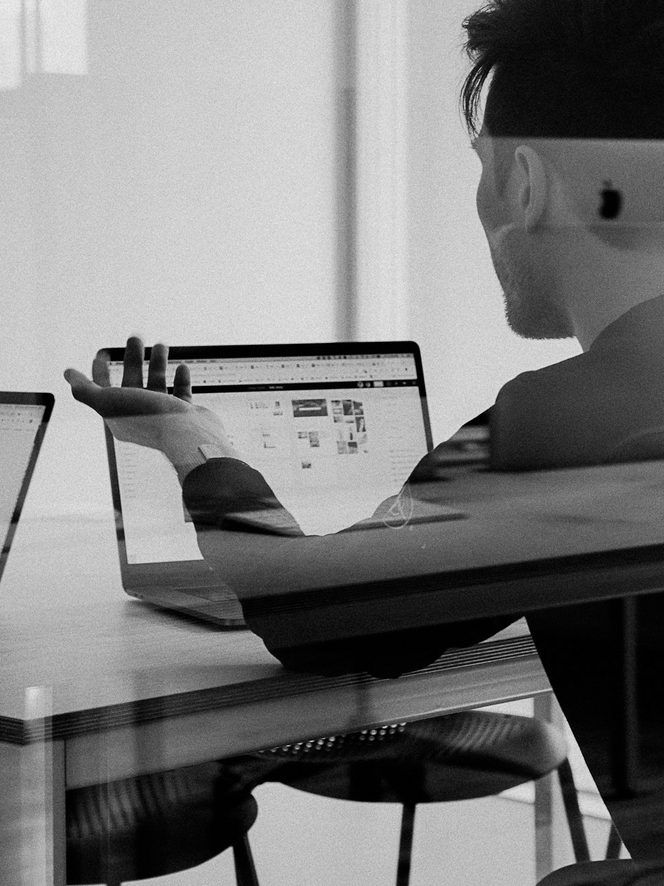 ein Mann sitzt an einem Laptop und erklärt etwas